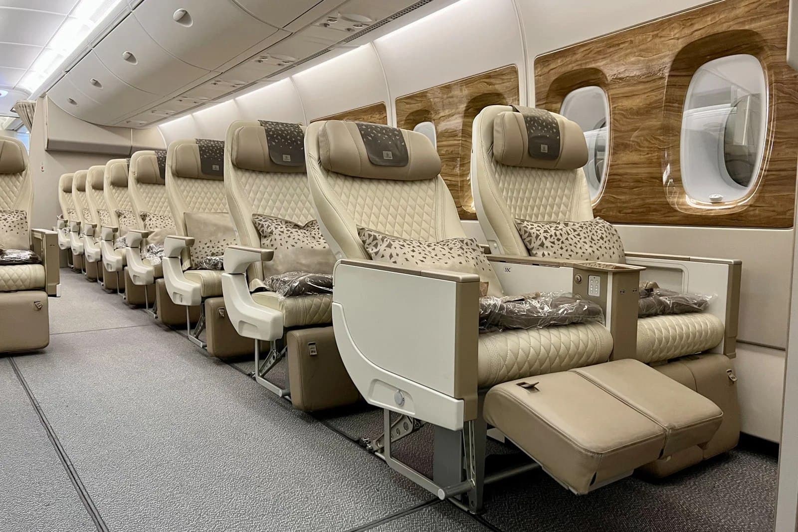 Premium economy cabin with wider seats, extra legroom, and a calm lighting mood on an international flight