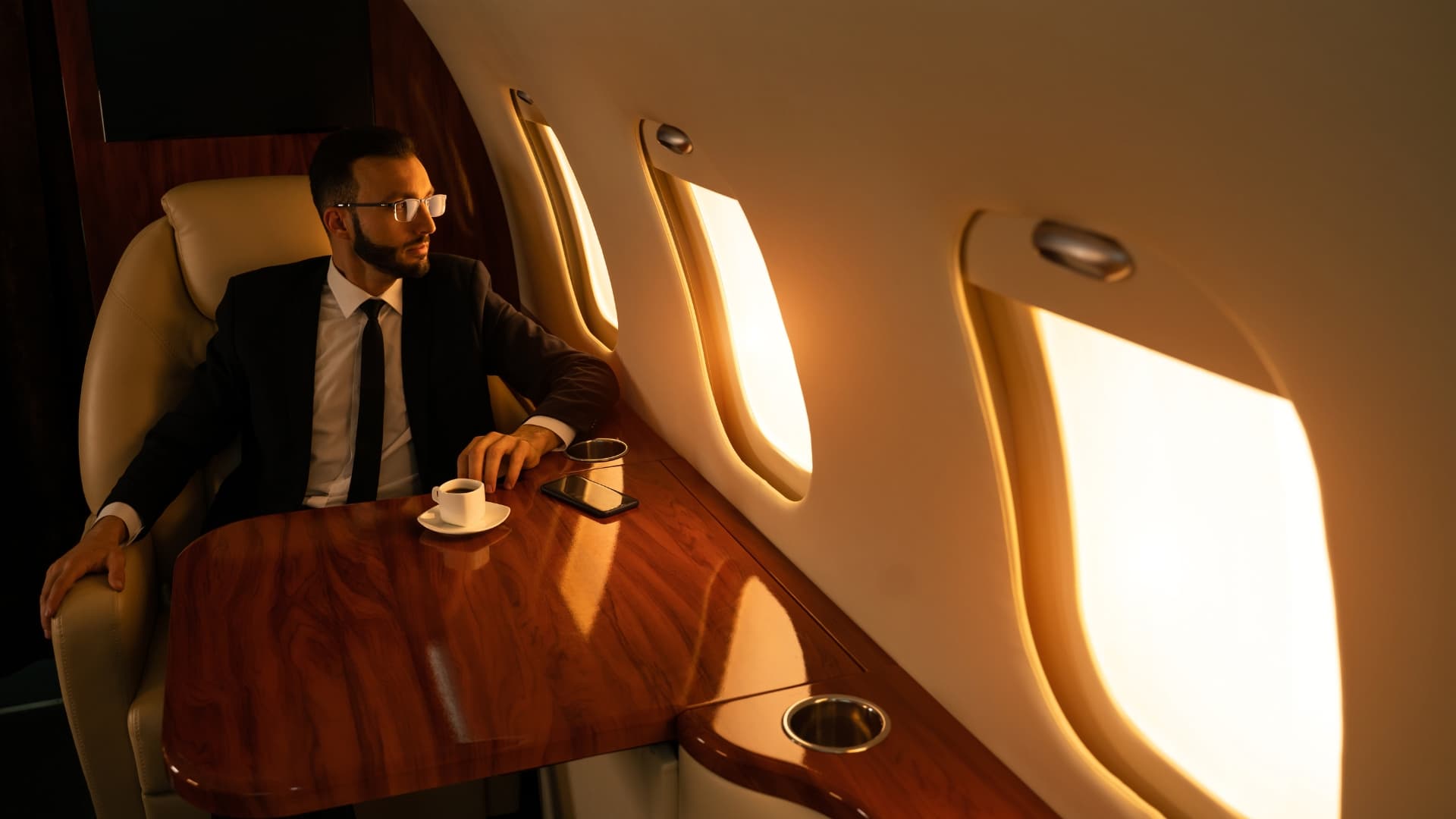 Luxury private jet interior with leather seating and warm golden cabin light